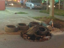  На улице Российской в Краснодаре огромную дорожную яму заделали покрышками 