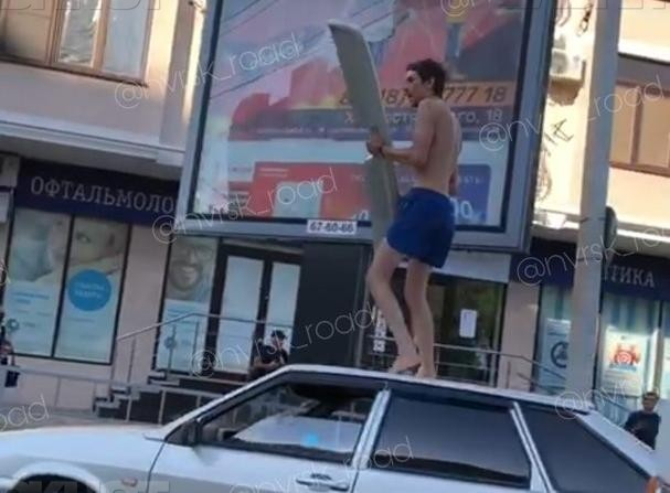 Неадекватный мужчина с крылом залез на крышу авто в Новороссийске