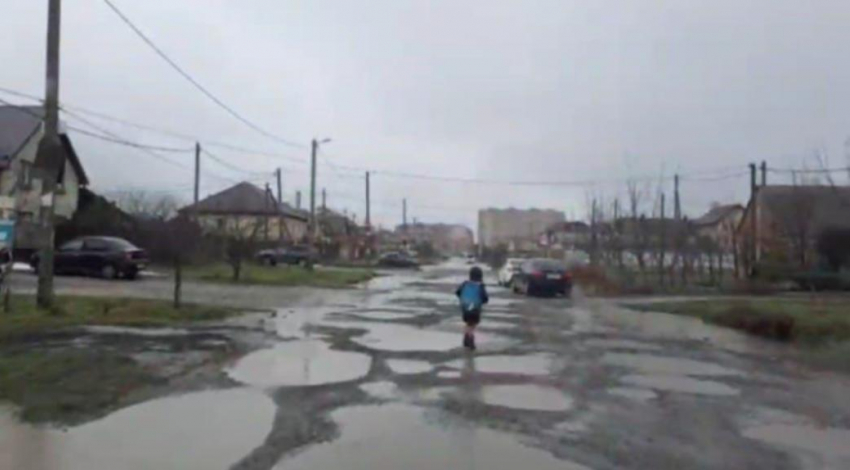 Переплыть ямы: попытки ребенка попасть в школу по жуткой дороге в Краснодаре сняли на видео